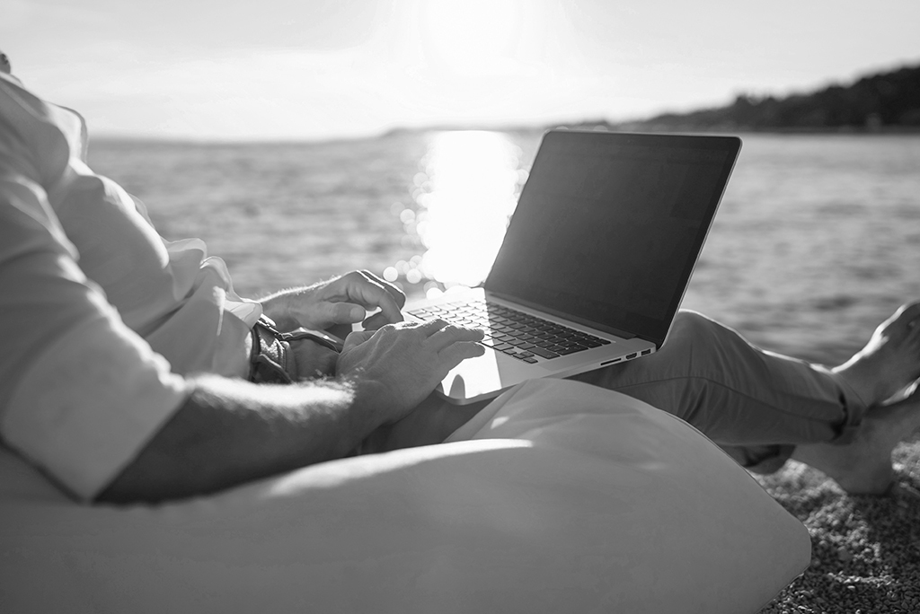 man working at computer on beach man working at computer on beach